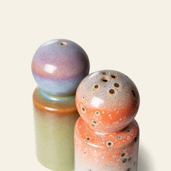The HKLIVING 70s Ceramics: Pepper & Salt Jar set features two rounded ceramic shakers—one in green, blue, and lavender gradient, the other speckled coral orange—bringing retro charm to any table. Both are shown on a light beige background.