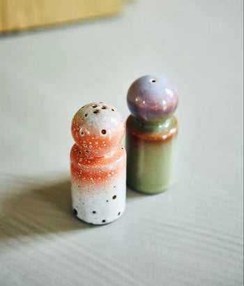 The HKLIVING 70s Ceramics: Pepper & Salt Jar set features retro-inspired jars—one in red, white, and speckled black, the other in green and purple—adding vintage HKLIVING charm to your space.