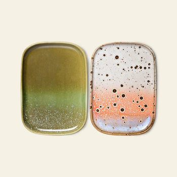 The HKLIVING 70s Ceramics: Small Trays, Set of 2 - Atlas features one tray with a glossy green gradient and one with a white, orange, and brown speckled design—both rectangular with rounded corners.