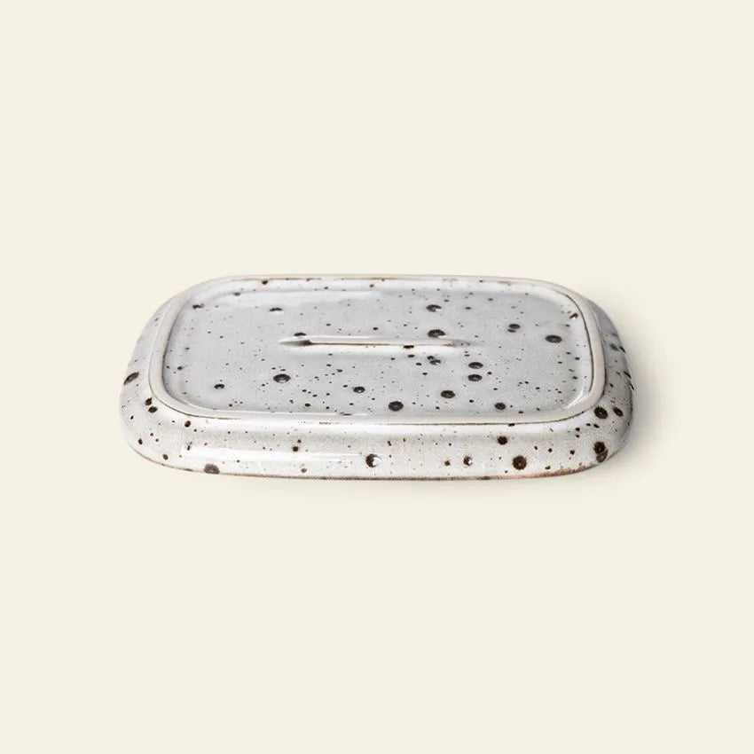 The HKLIVING 70s Ceramics Small Trays, Set of 2 - Atlas, feature a rectangular design with rounded edges, a white glaze with dark speckles, and a central drainage slot, inspired by vintage ceramics.