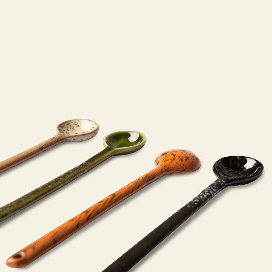 The HKLIVING 70s Ceramics: Spoons L, Set of 4 features retro spoons in beige, green, orange-brown, and black with unique patterns, stylishly arranged on a light neutral background.