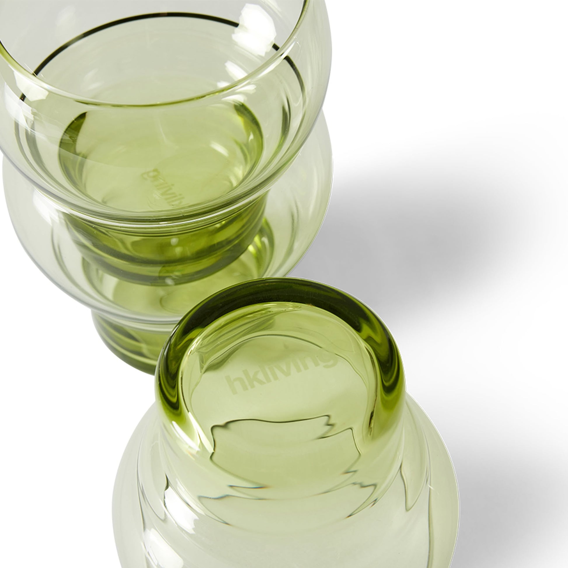 Two HKLIVING 70s Glassware Bulb Glasses, from a set of 4, sit stacked rim-to-rim on a white surface with soft shadows. The upward-facing cup shows the etched HKLIVING logo, echoing retro design.