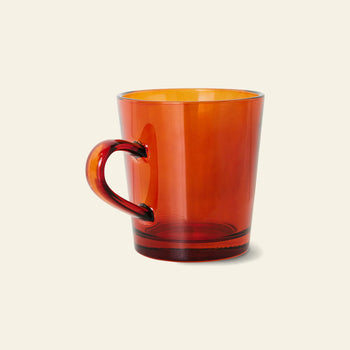 The HKLIVING 70s Glassware: Coffee Cups, Set of 4 features translucent amber glass mugs with rounded handles, inspired by vintage 70s design, displayed against a light beige background.