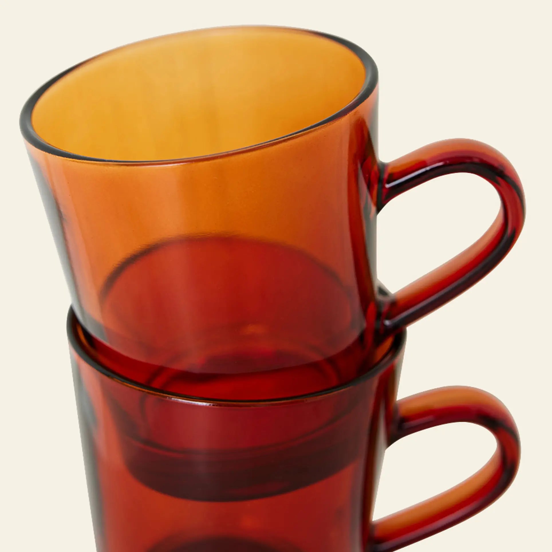 The HKLIVING 70s Glassware Coffee Cups, Set of 4, features translucent orange and deep red cups with curved handles and a retro 70s vibe, stacked stylishly against a light background.