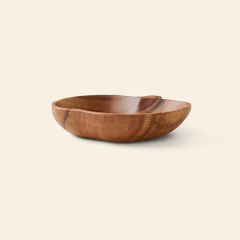 The HKLIVING Acacia Apple Bowl M is a handcrafted, shallow, round bowl made from sustainable acacia wood with a smooth finish, showcased on a light cream background.