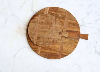 Two HKliving Bread Board Reclaimed Teak, Medium boards are stacked on white marble. Their rustic wood tones add warmth, with one board slightly off-center atop the other. Brand: HKliving.