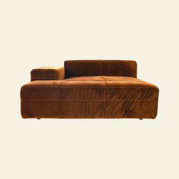 The HKLIVING Brut Sofa, Left by HKLIVING features a modern, plush brown velvet design with sleek curves, a low backrest, and a single left armrest, creating casual comfort against a plain off-white background.