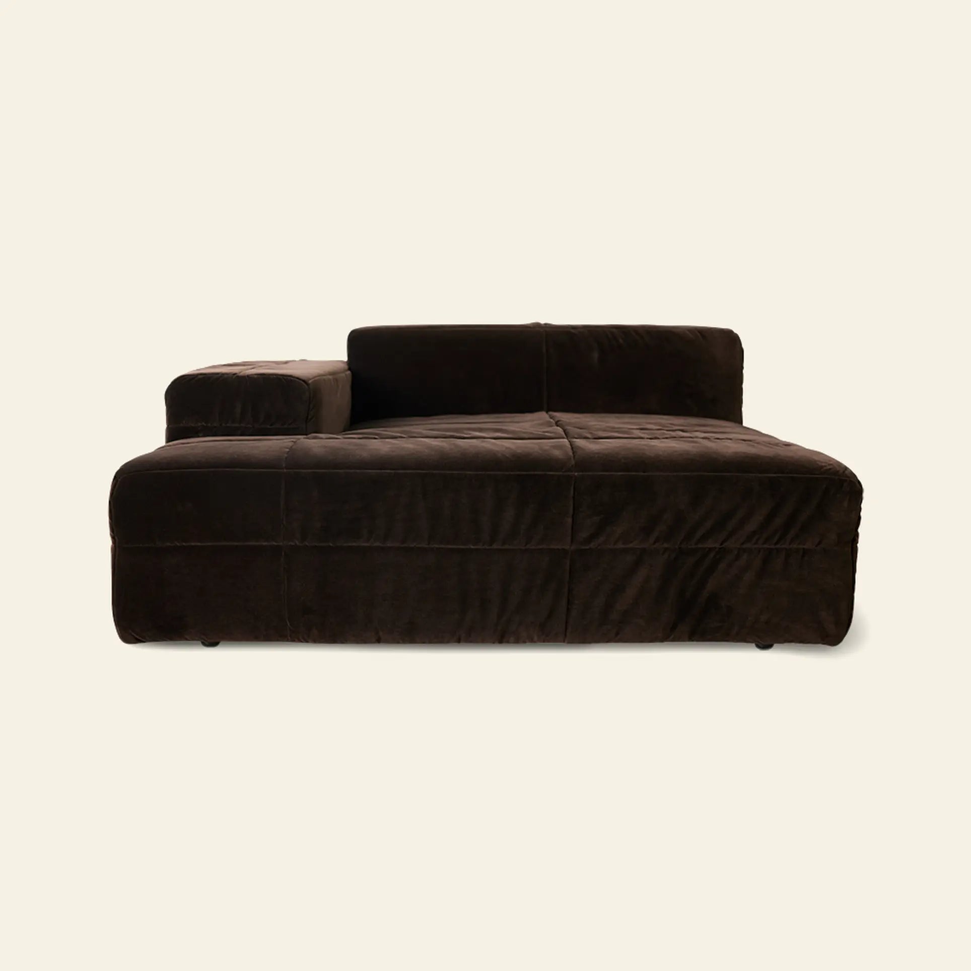 The HKLIVING Brut Sofa, Left by HKLIVING is a modern, low-profile chaise lounge in dark brown velvet with sleek curves, a single left armrest, and wide seat cushions, set against an off-white background.