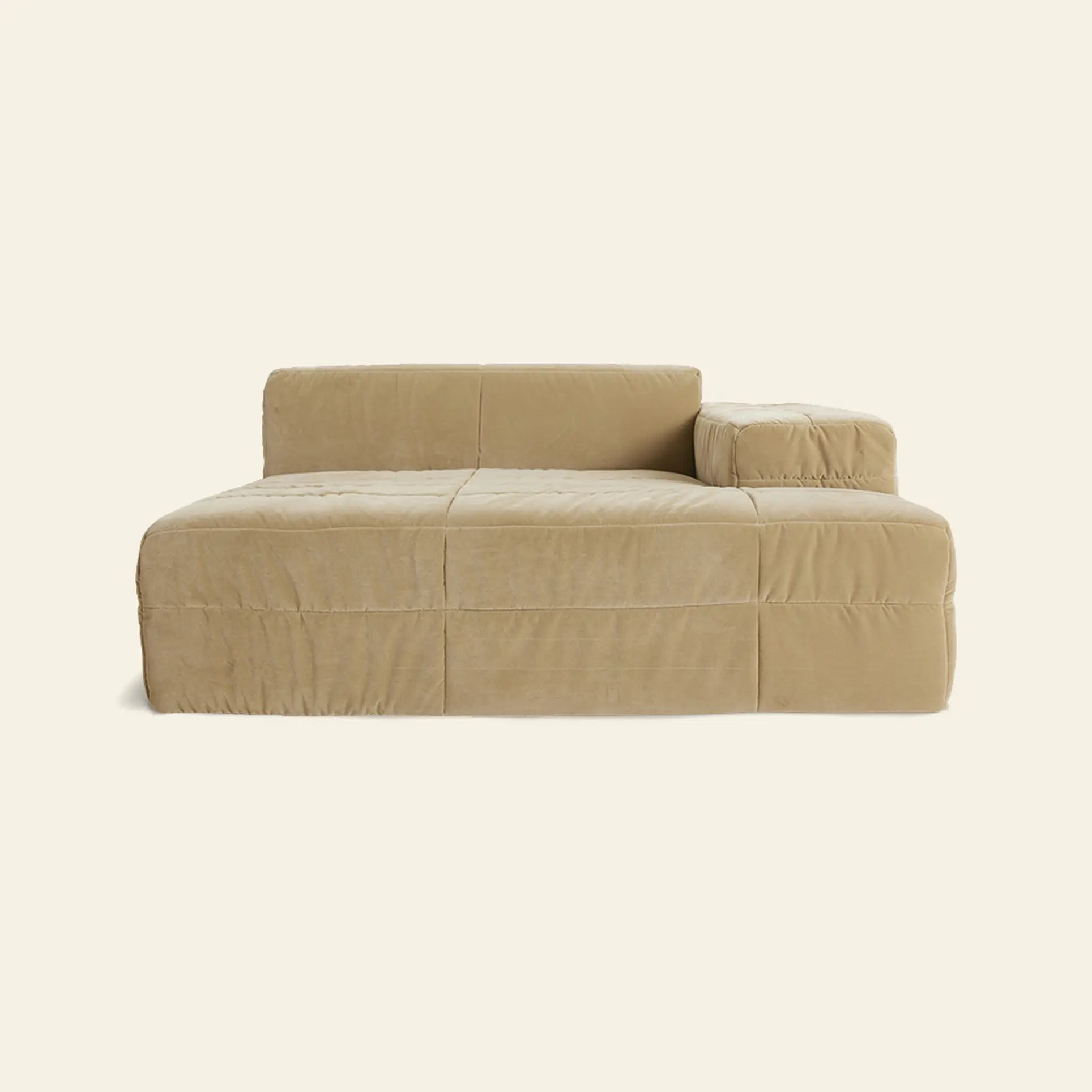 The HKLIVING Brut Sofa, Right Divan by HKLIVING features a beige, modern sculptural design with a low backrest and one large right armrest. Its minimalist, boxy form includes soft plush cushions and is shown against an off-white background.