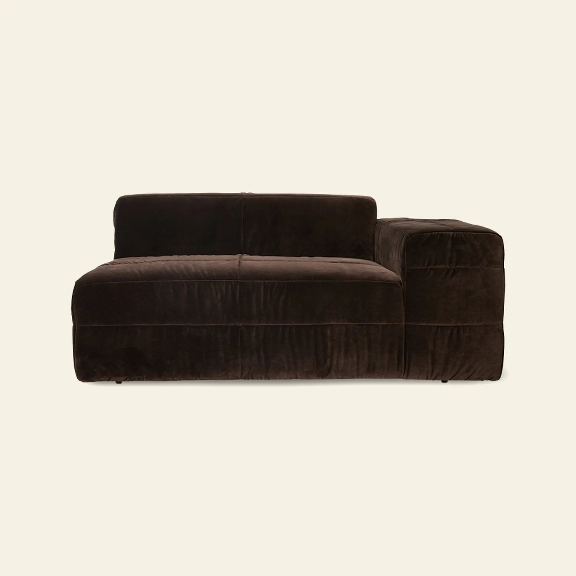 The HKLIVING Brut Sofa, Right by HKLIVING is a modern dark brown velvet sectional with a bold design, low back, and right-side armrest. Its cozy look stands out against a plain beige background.