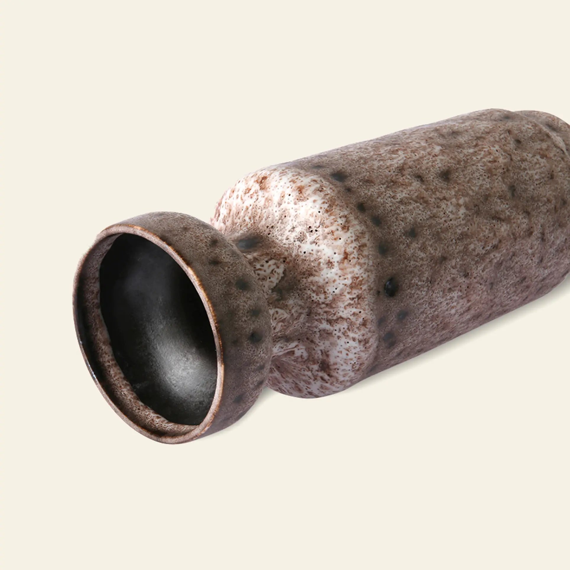 The HKLIVING Ceramic Retro Vase by HKLIVING, featuring a wide flared mouth and a brown and white speckled glaze, rests on its side against a plain light background.