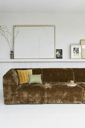 A brown corduroy sofa with mustard and green pillows sits in a bright room. Behind it, white shelves display minimalist framed art and the HKLIVING Ceramic Retro Vase, while a coffee cup and magazine rest on the couch.