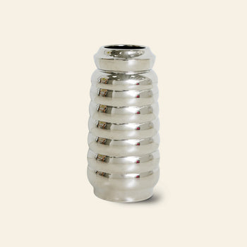 The HKLIVING Ceramic Ribble Vase features a shiny silver ribbed design with a rounded, cylindrical shape and mirrored finish, set against a light beige background—ideal for modern interiors.