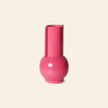The HKLIVING Ceramic Vase Hot Pink features a glossy round base and tall cylindrical neck, making it a bold pink accent against a plain light beige background.