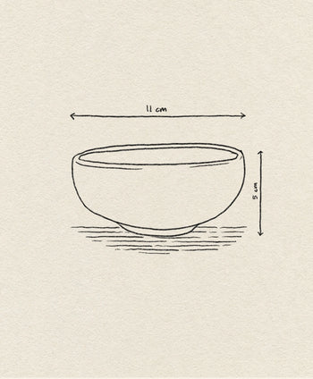 A simple line drawing of the HKLIVING Chef Ceramics: Bowl (11 cm wide, 5 cm tall) by HKLIVING, crafted from durable porcelain. Arrows indicate its dimensions as it sits on a textured surface.