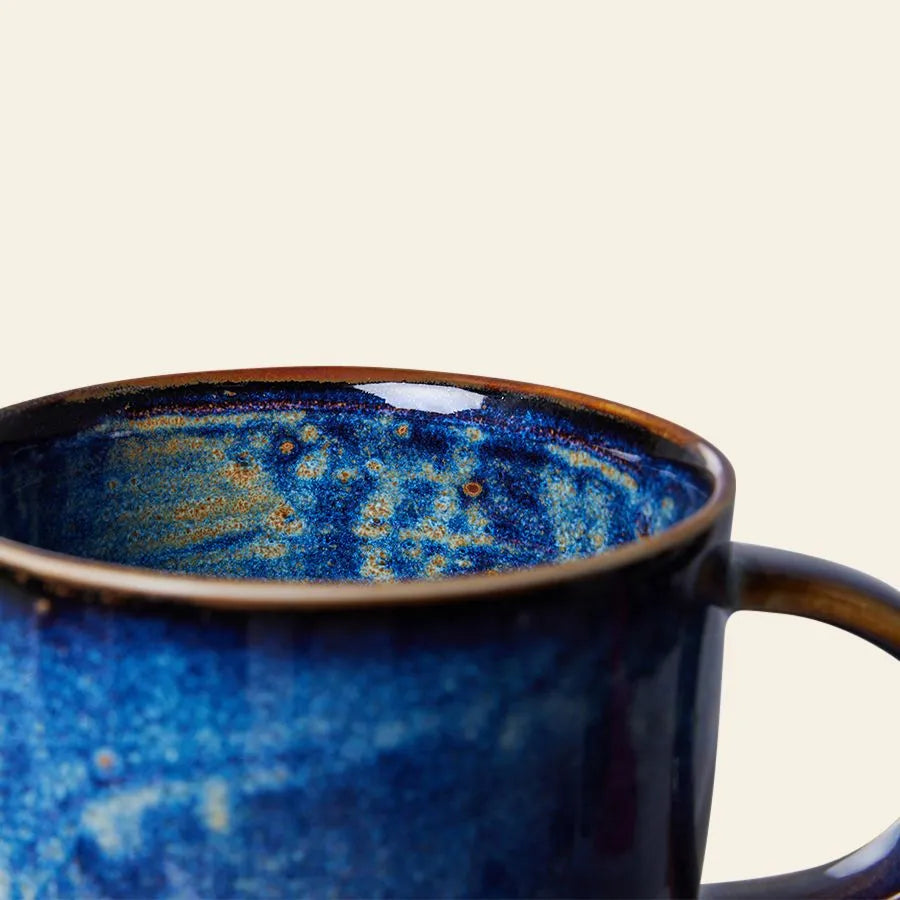 A close-up of the HKLIVING Chef Ceramics: Mug by HKLIVING, featuring a glossy blue and brown marbled glaze on the rim and handle, set against a plain light background.