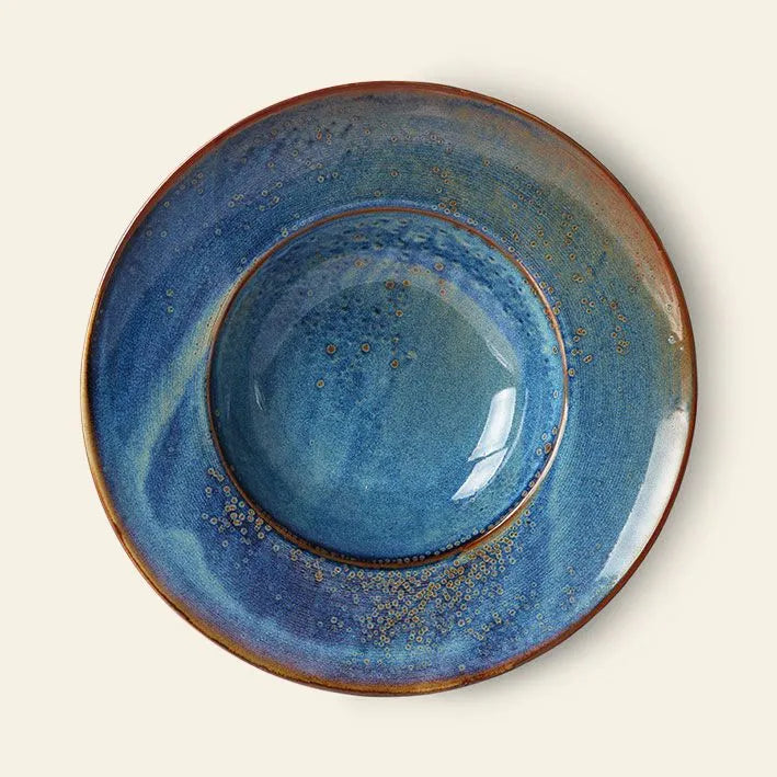 The HKLIVING Chef Ceramics: Pasta Plate by HKLIVING is a handcrafted ceramic plate with a wide rim, glossy blue glaze with swirls and speckles, and a brownish edge, shown from above on a light background.