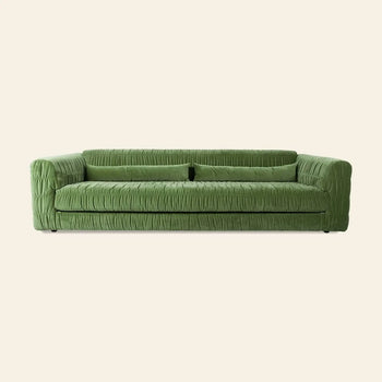 The HKLIVING Club Couch by HKLIVING features modern green pleated upholstery, a wrinkled fabric texture, low backrest, and wide armrests—an ideal statement piece for contemporary interiors.