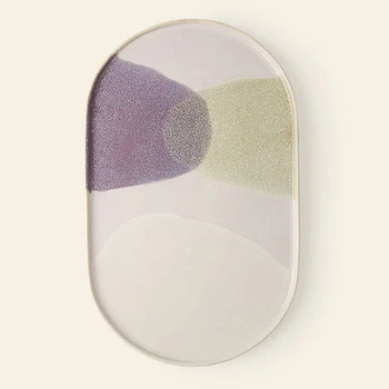 The HKliving Gallery Ceramics Oval Dinner Plate features a glossy white finish with abstract patches of lavender, pale green, and off-white overlapping at the center on a light beige background.