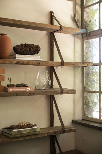 A rustic wooden bookshelf displays books, a HKLIVING Glass Bum Vase, a terracotta pot, and natural accents. Sunlight streams through a window with green leaves outside, creating a warm and peaceful ambiance.