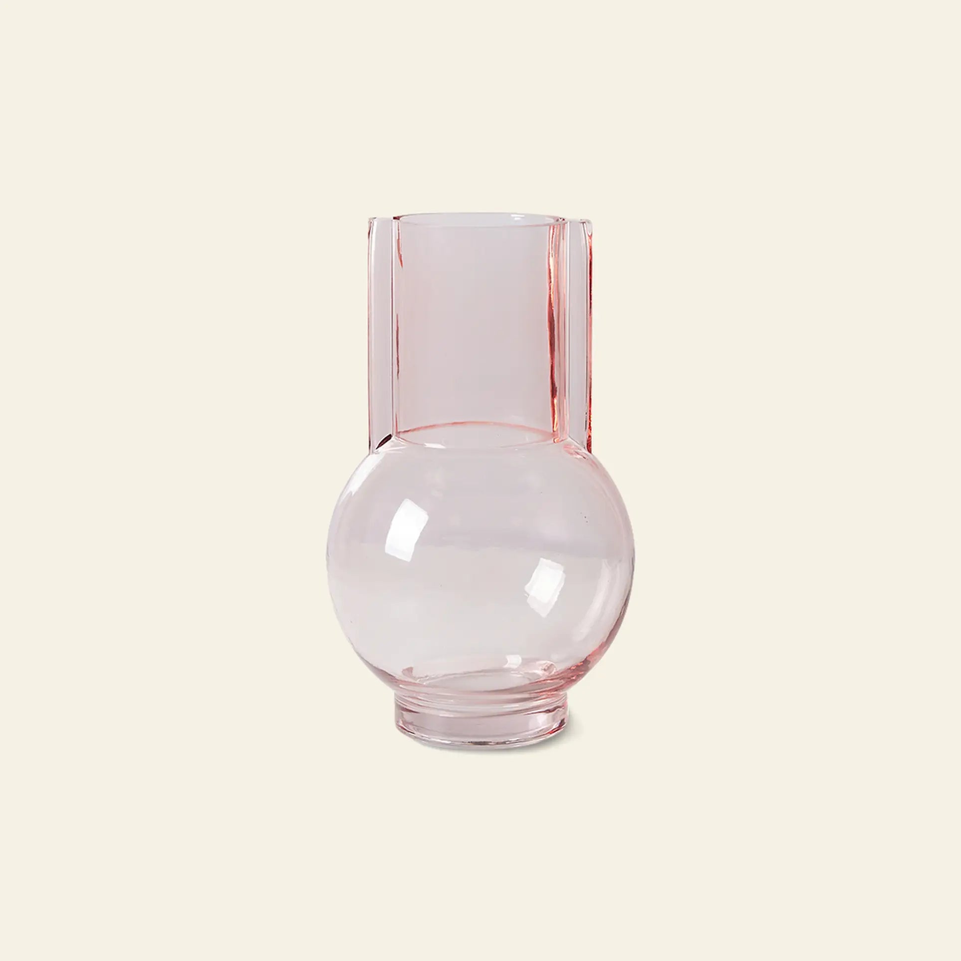The HKLIVING Glass Vase Sundae Pink by HKLIVING features clear, light pink glass with a round base and tall cylindrical neck, ideal for contemporary decor. It is displayed against a plain beige background.