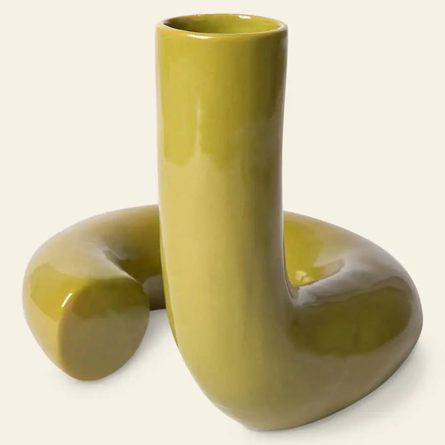The HKliving HK Objects: Ceramic Twisted Vase by HKliving features a glossy olive finish and a unique curved design, resembling an abstract sculpture, displayed against a plain light background.