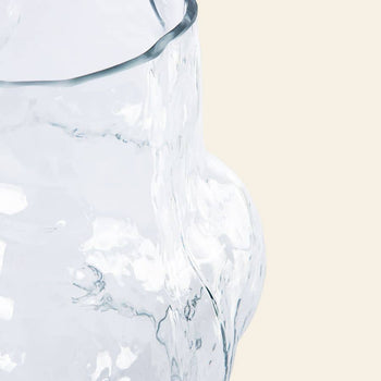 Close-up of the HKliving HK Objects: Cloud Vase Clear Glass High by HKliving, featuring a wavy, irregular surface—an eye-catching accent piece for home decor—set against a light beige background.