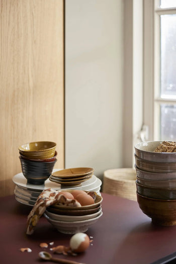 A cozy kitchen scene with HKLIVING Kyoto Ceramics: Japanese Matcha Bowls, Set of 3, stacked on the counter. Some bowls hold grains, while another cradles a cloth with eggs and eggshells as sunlight fills the space.