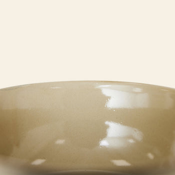 Close-up of the rim of a glossy, beige ceramic bowl from HKLIVING Kyoto Ceramics: Japanese Noodle Bowls, Set of 4—echoing hand-finished bowls typical in Kyoto—set against a plain, light background.