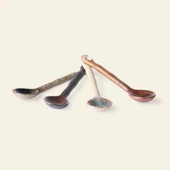 The HKLIVING Kyoto Ceramics: Japanese Tea Spoons, Set of 4, features ceramic spoons in gray, black, white, and brown arranged fan-like on a beige background, showcasing HKLIVING's elegant Kyoto-inspired design.