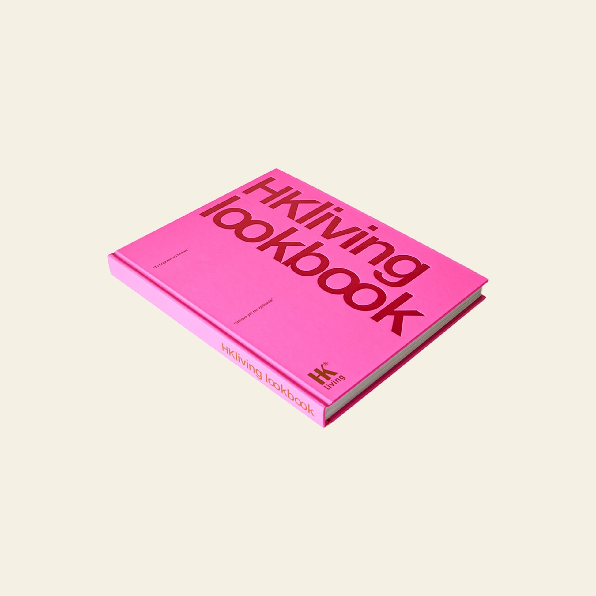 A closed, bright pink HKLIVING Limited Edition Lookbook '22 coffee table book with bold red lettering from HKLIVING, shown against a plain light background.