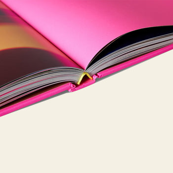 A close-up of the HKLIVING Limited Edition Lookbook '22 by HKLIVING, featuring bright pink pages and cover with visible spine and binding, set against a plain light background—ideal for bold visual enthusiasts.