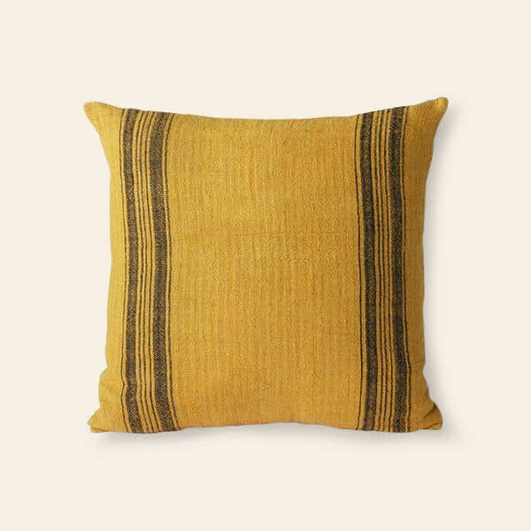 The HKliving Linen Cushion by HKliving is a square, mustard-colored linen piece with two vertical black stripes near each edge, making it a stylish decor accent against a plain light background.