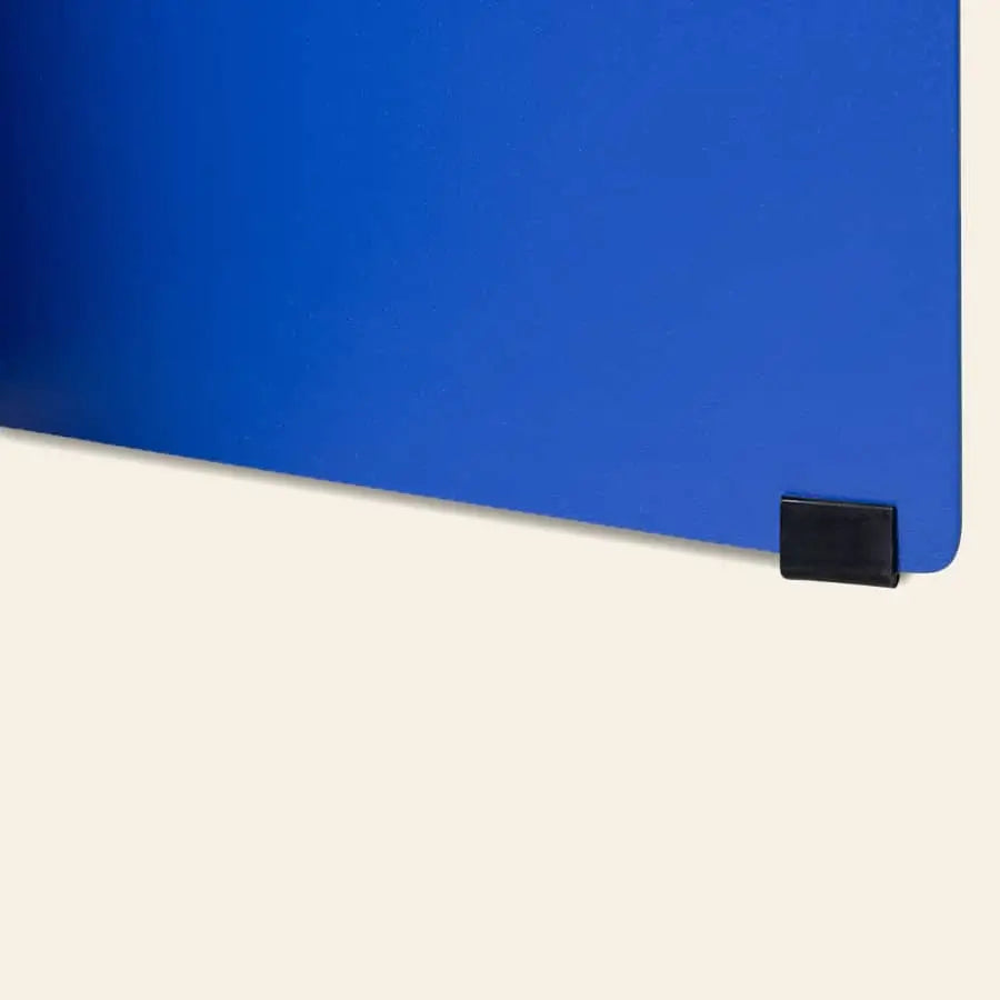 A close-up of the HKLIVING Metal Side Table Round by HKLIVING, featuring a blue surface and a small black clip on the lower right, set against a light beige background.