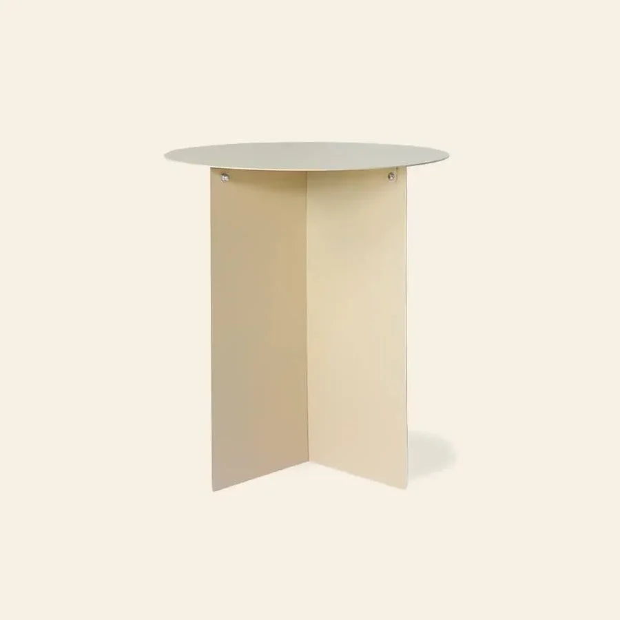 The HKLIVING Metal Side Table Round by HKLIVING features a minimalist design with a light beige top and two intersecting flat panel legs, shown against a plain off-white background.