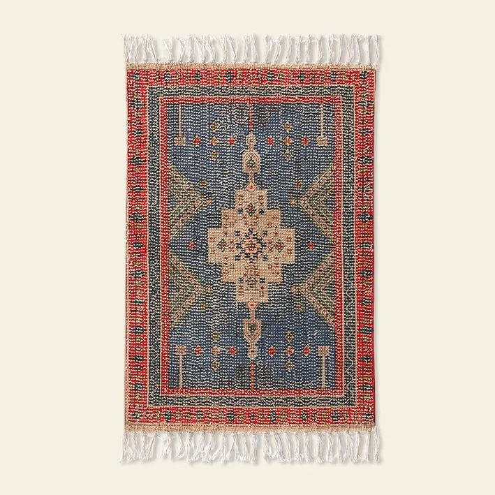 The HKLIVING Printed Bathmat Overtufted by HKLIVING is a rectangular mat with an intricate geometric pattern in blue, red, beige, and green, a central medallion, white fringe on short edges, and an anti-slip backing for safety.