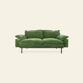 The HKLIVING Retro Sofa, a modern green velvet 2-seater with plush cushions, wide armrests, and black metal legs by HKLIVING, is showcased against a plain light beige background.
