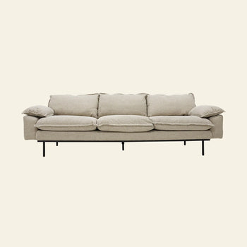 The HKLIVING Retro Sofa, 4-Seats by HKLIVING is a modern light beige sofa with four seat cushions, plush armrests, vintage style, minimalist design, and thin black metal legs. It is shown against a plain off-white background.