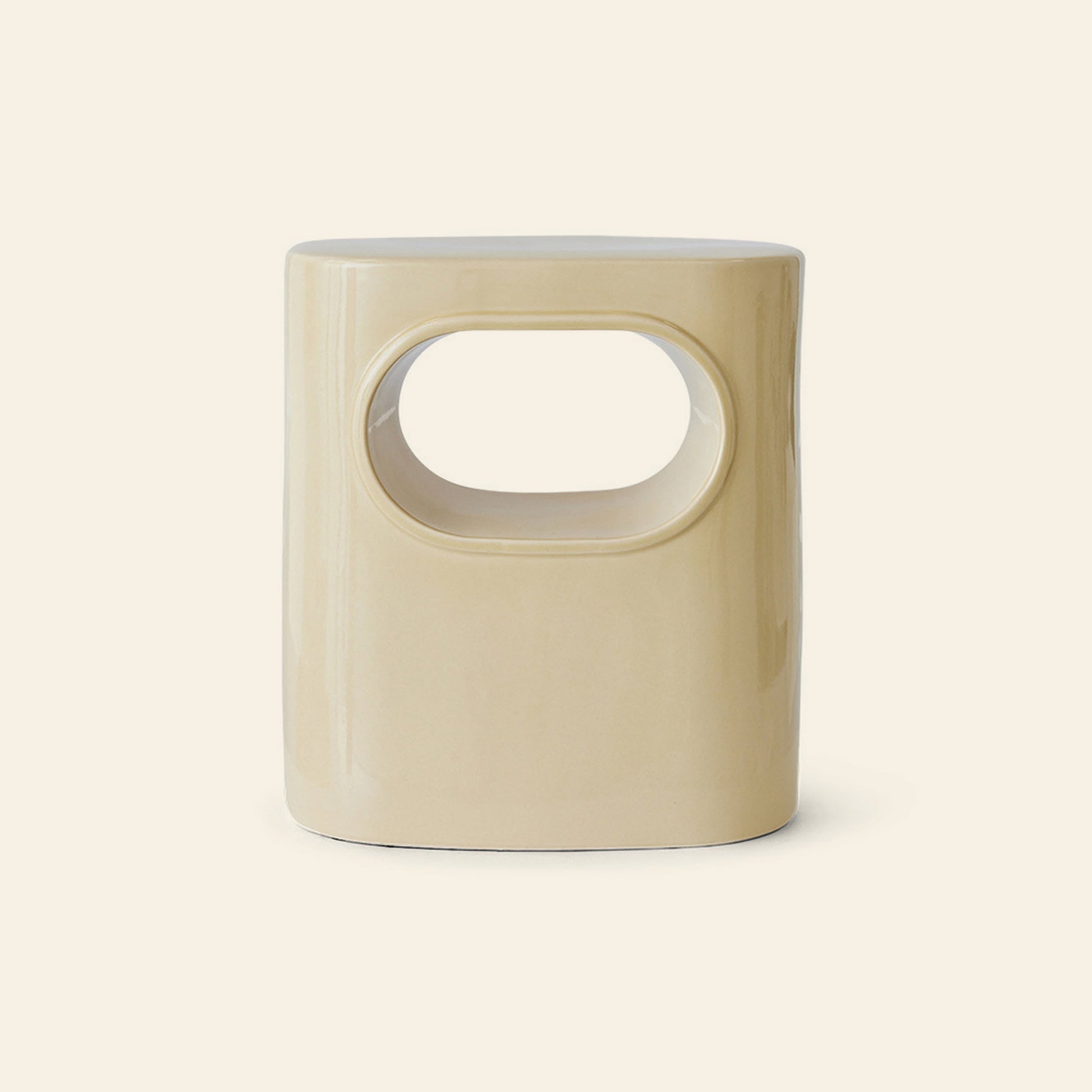 The HKLIVING Space Side Table by HKLIVING is a beige, cylindrical ceramic stool with a smooth finish and large oval cutout, perfect as a side table or storage—ideal for modern spaces. Set against a plain light background.