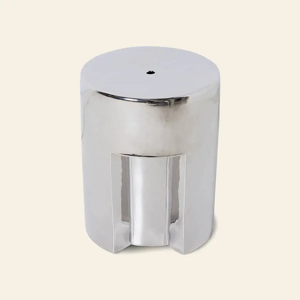 The HKLIVING Stoneware Side Table - Chrome by HKLIVING is a shiny, cylindrical side table with a smooth, reflective surface and a small round hole on top, shown against a light beige background.