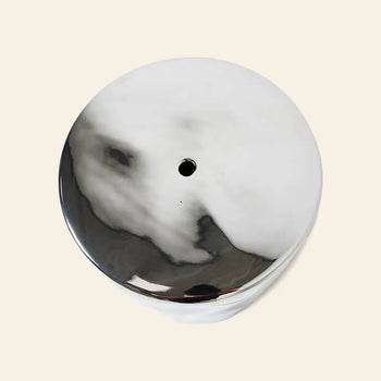 The HKLIVING Stoneware Side Table - Chrome by HKLIVING features a round, marble-like shape with a small central hole and a shiny chrome surface, resembling sleek modern style against a light background.
