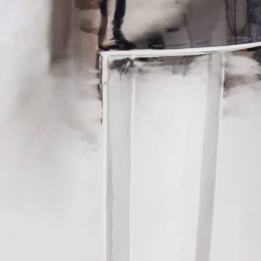 Close-up view of the HKLIVING Stoneware Side Table - Chrome, showcasing its shiny, metallic surface with reflective and subtly distorted textures. Clean lines and smooth areas emphasize HKLIVING’s modern, futuristic design.