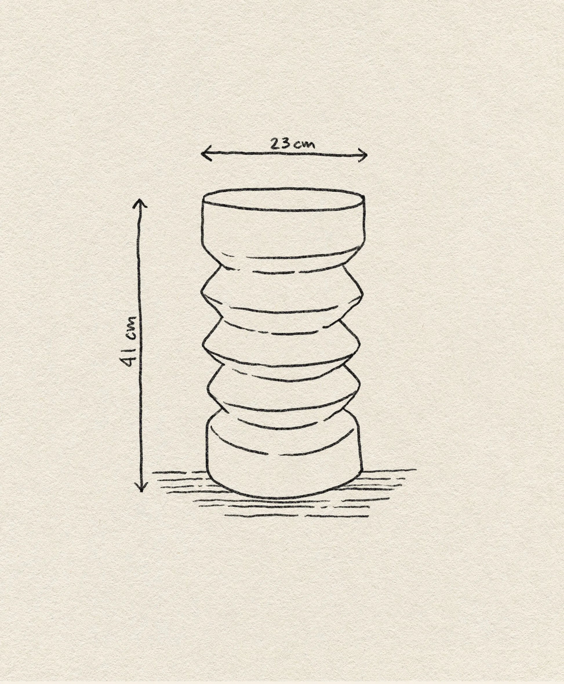 A line drawing of the HKLIVING Stoneware Side Table by HKLIVING, featuring a cylindrical, sculptural shape with wavy contours. Dimensions: 23 cm wide, 41 cm tall. The table stands upright on a textured surface.