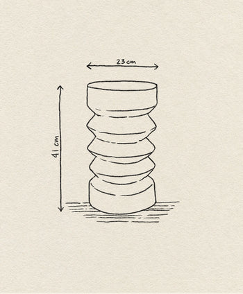 A line drawing of the HKLIVING Stoneware Side Table by HKLIVING, featuring a cylindrical, sculptural shape with wavy contours. Dimensions: 23 cm wide, 41 cm tall. The table stands upright on a textured surface.