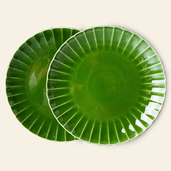 The HKliving The Emeralds: Ceramic Dinner Plate Ribbed, Set of 2 features glossy, emerald green plates with white rims and a fluted pattern. The ceramic plates overlap slightly against a plain, light background.