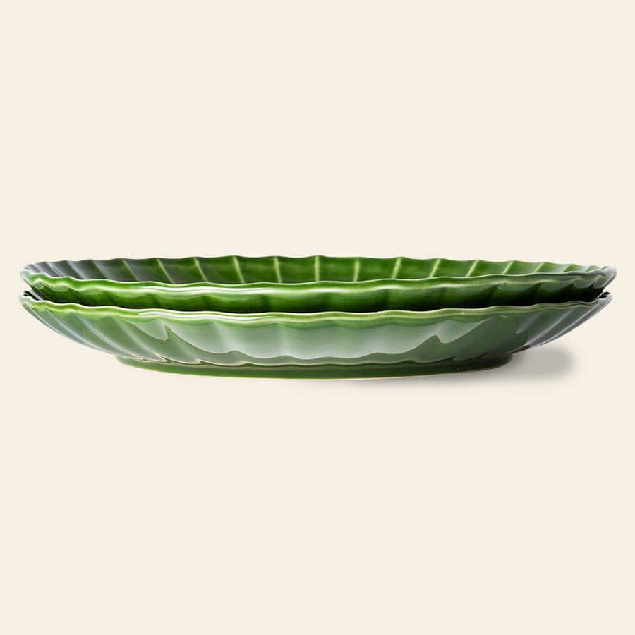 The HKliving The Emeralds: Ceramic Dinner Plate Ribbed, Set of 2, features two leaf-shaped, emerald green ceramic plates stacked side view on a beige background—ideal as elegant small meal plates.
