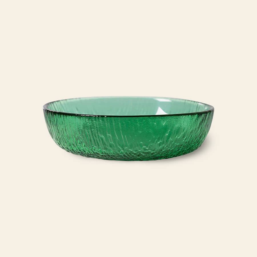 The HKliving The Emeralds: Glass Dessert Bowl, a round, shallow bowl with textured green glass, is shown on a light beige background, showcasing modern elegance.