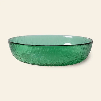 The HKliving The Emeralds: Glass Salad Bowl features round, textured emerald green glass with slightly flared edges, displayed against a plain beige background.