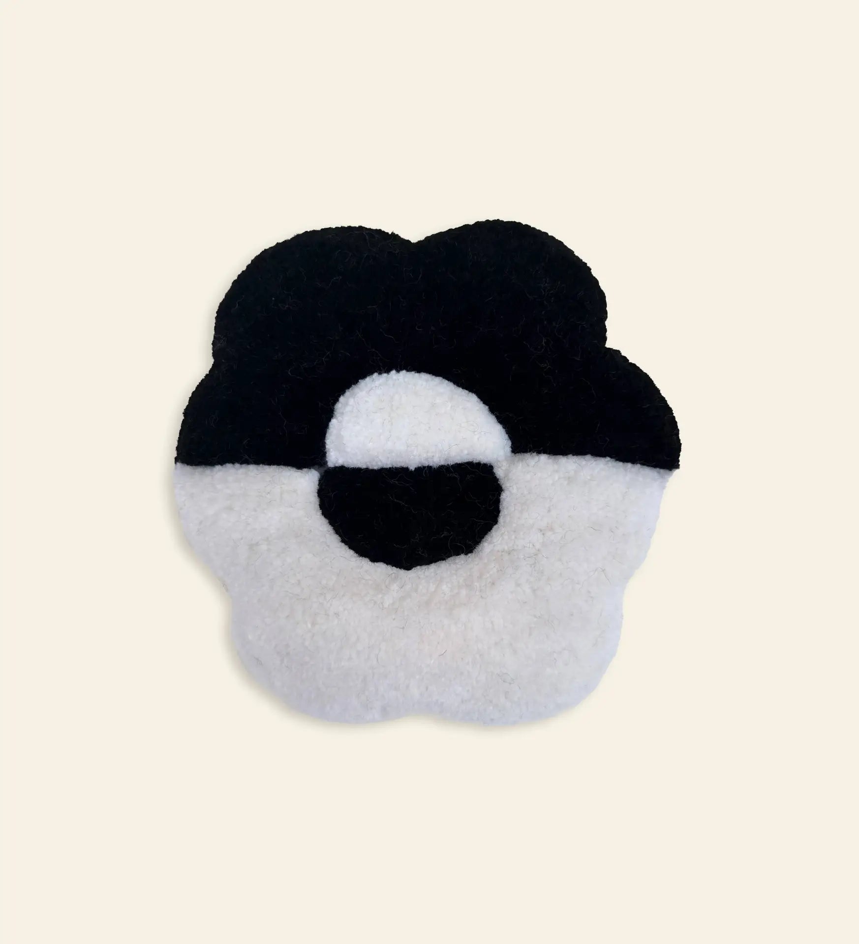 The Habichl Tufted Coasters by Habichl feature a plush, five-petal flower shape with a unique black and white tufted design and circular center, adding charm to any beige background.