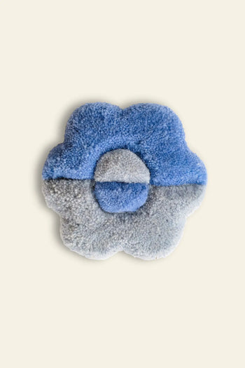 The Habichl Tufted Coasters by Habichl feature a unique flower-shaped design with blue and gray petals and a circular center, shown against a plain beige background.